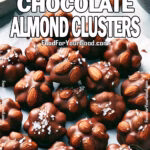 Homemade 3-Ingredient Chocolate Almond Clusters on parchment paper, sprinkled with flaky sea salt – easy no-bake dessert from FoodForYourGood.com